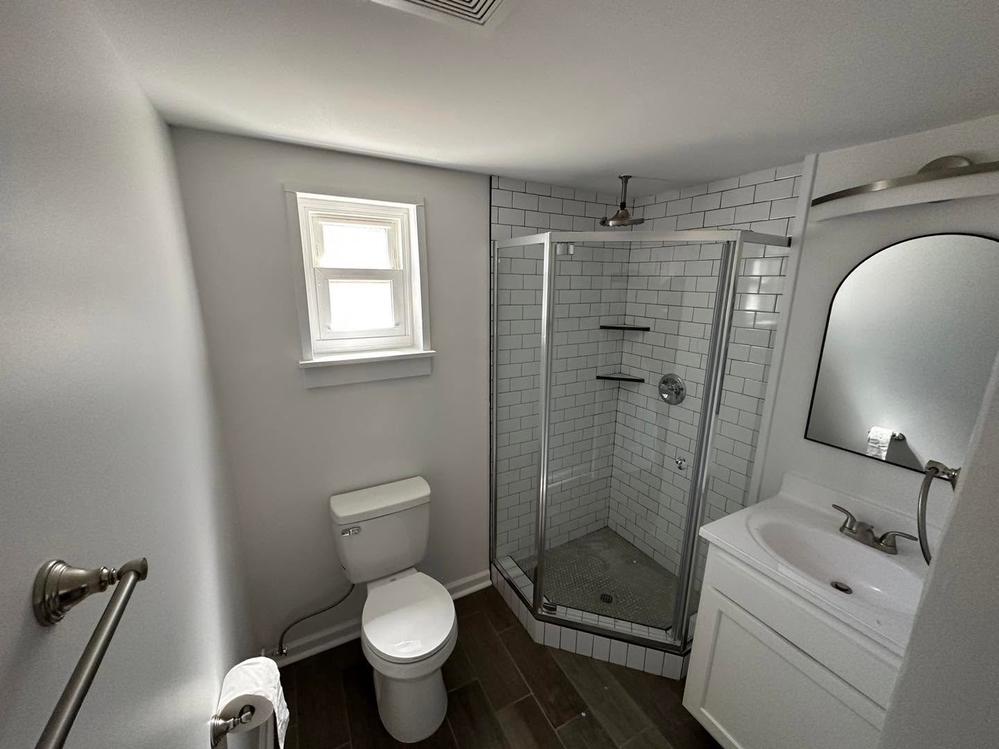 Corner glass shower with white subway tile
