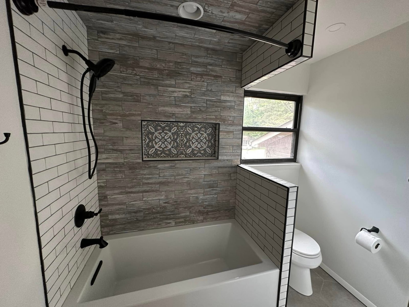 Tub shower with wood-look tile feature wall and subway tile